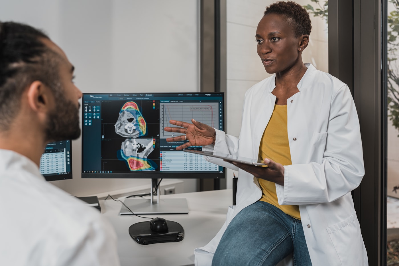 Two clinicians reviewing records together at a workstation